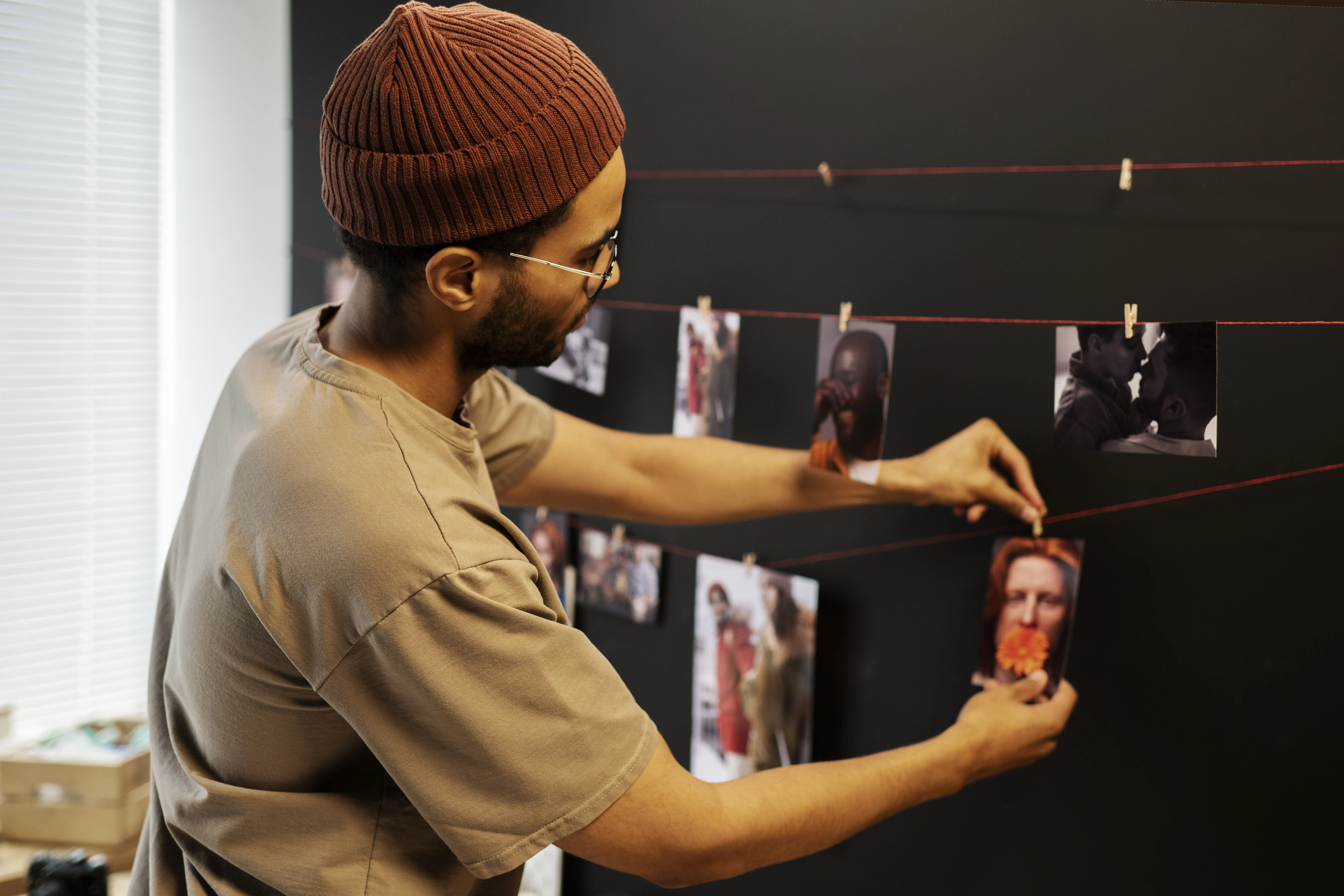 Halbnahe Aufnahme eines Mannes, der in der Dunkelkammer Fotos entwickelt.